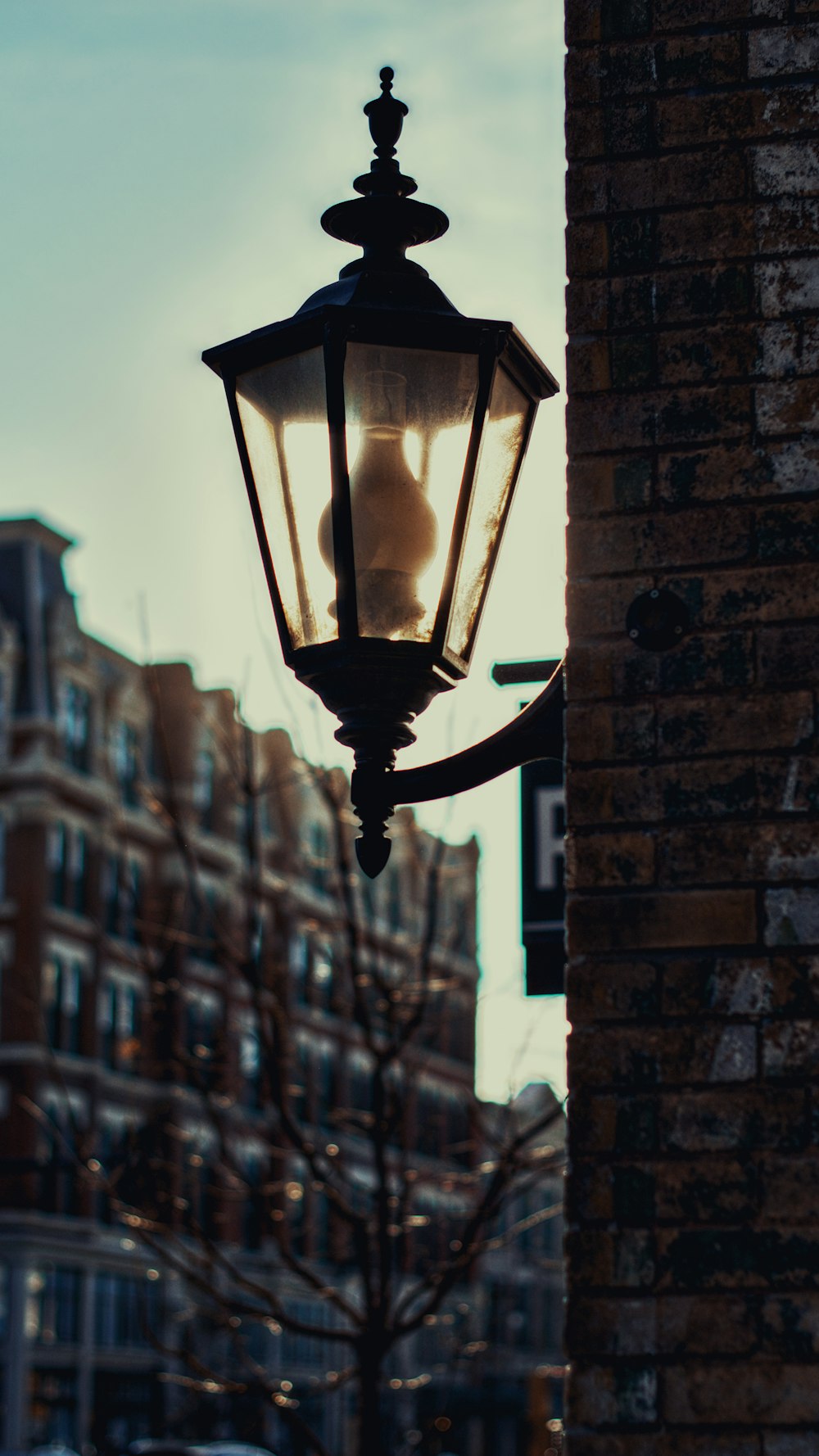 a street light hanging off the side of a brick building