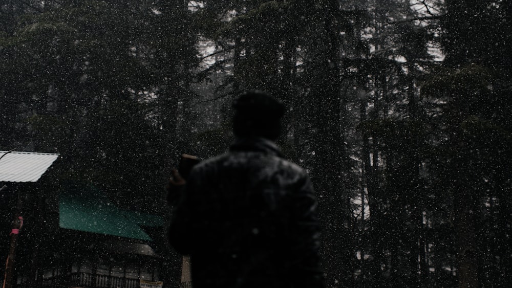 a man standing in the rain with an umbrella