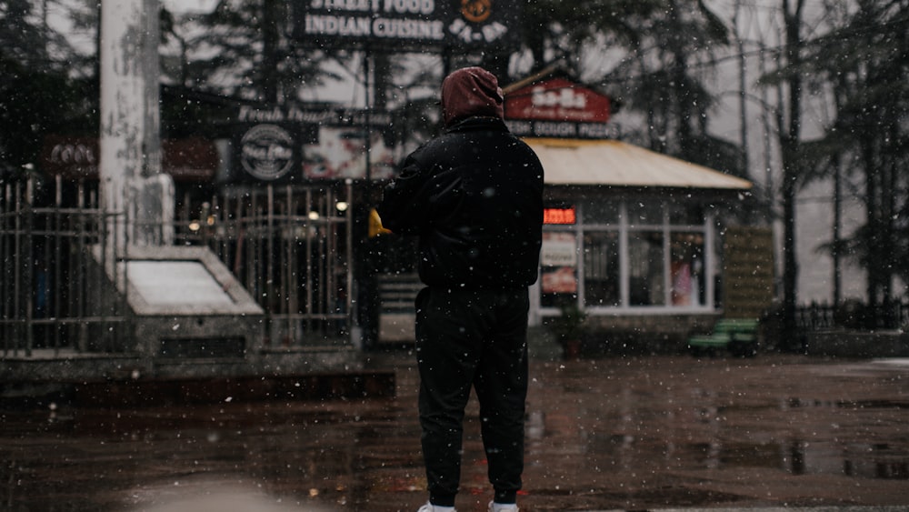 a man standing on a sidewalk in the rain