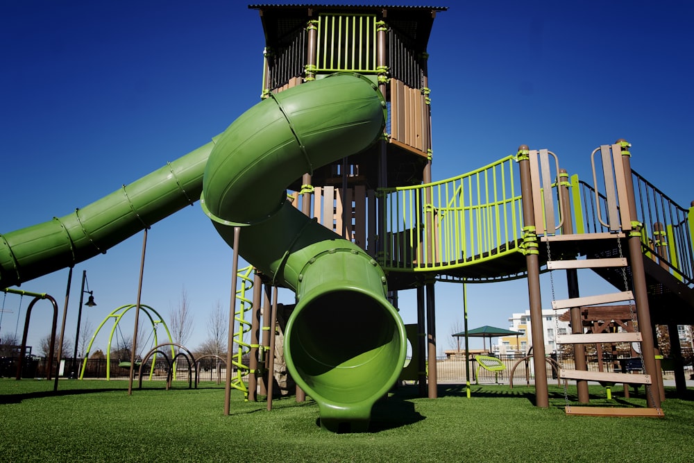 a playground with a green slide and a green slide