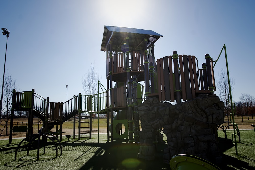 a playground with a rock wall and a play structure