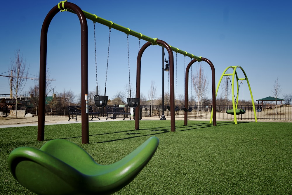 a playground with swings and a green slide