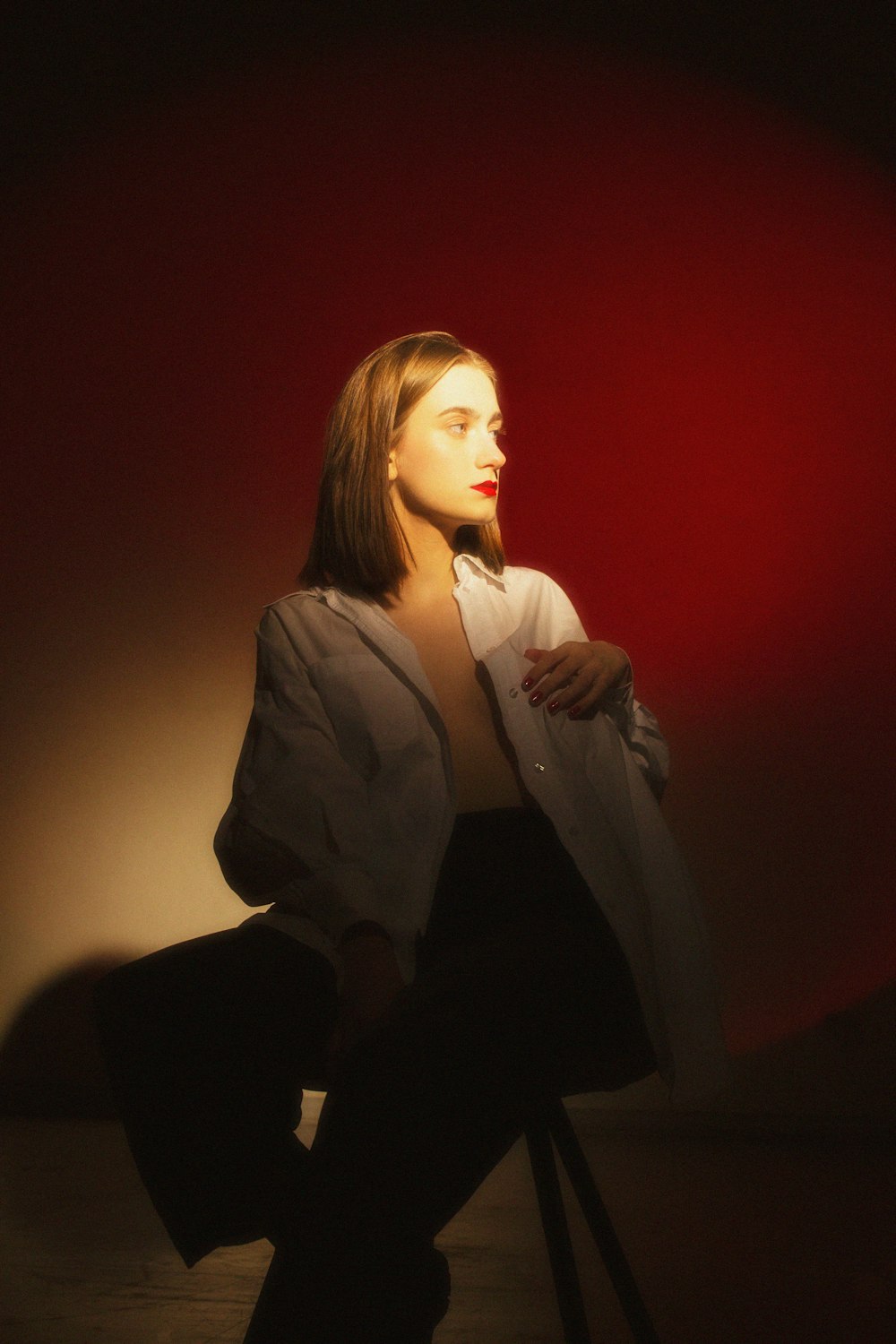 a woman sitting on a chair in a dark room