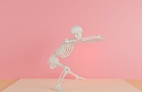 a skeleton is standing on one leg and pointing at something