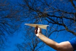 a man holding a paper airplane in his hand