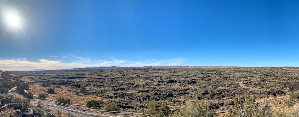 una vista panoramica di una valle con una recinzione in primo piano