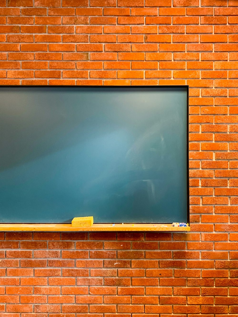 a blackboard mounted to a brick wall