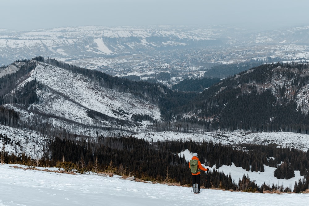 a man standing on top of a snow covered slope