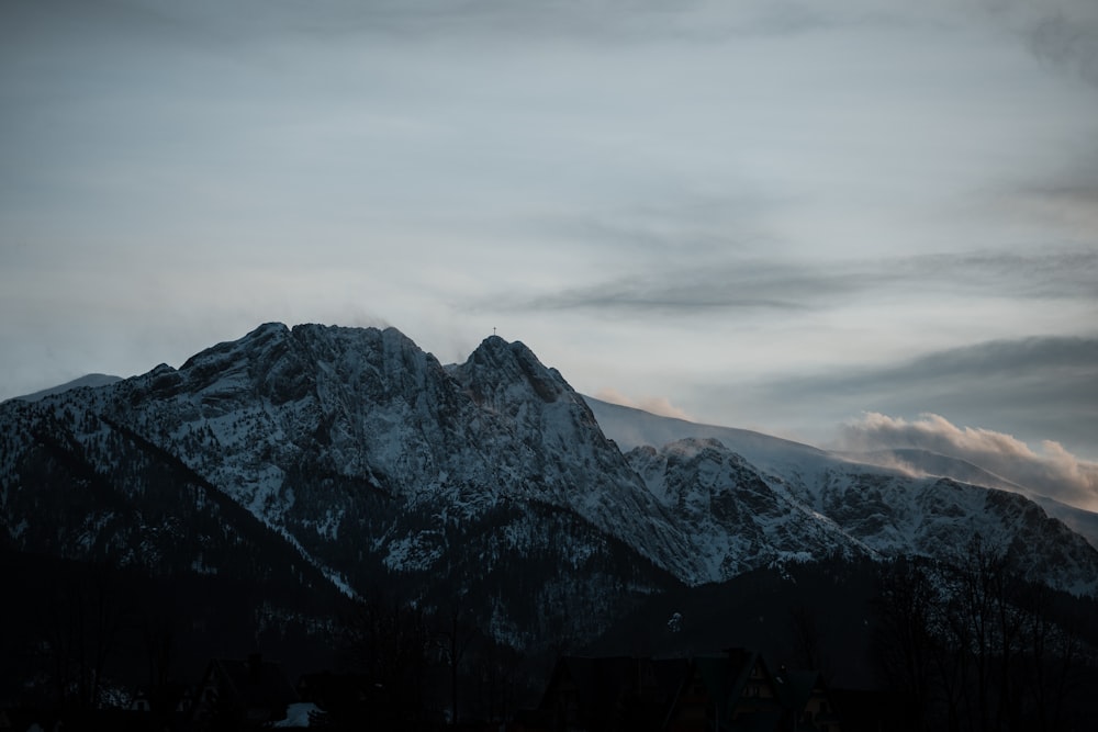 a snow covered mountain with clouds in the sky