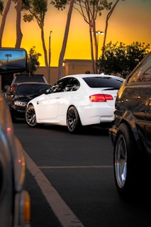 A sleek white Toyota Hiace parked at a busy airport drop-off zone during sunset.