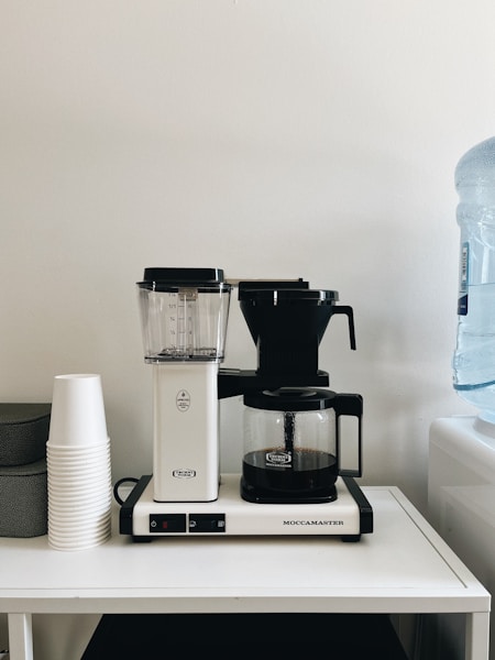 a coffee maker sitting on top of a white table
