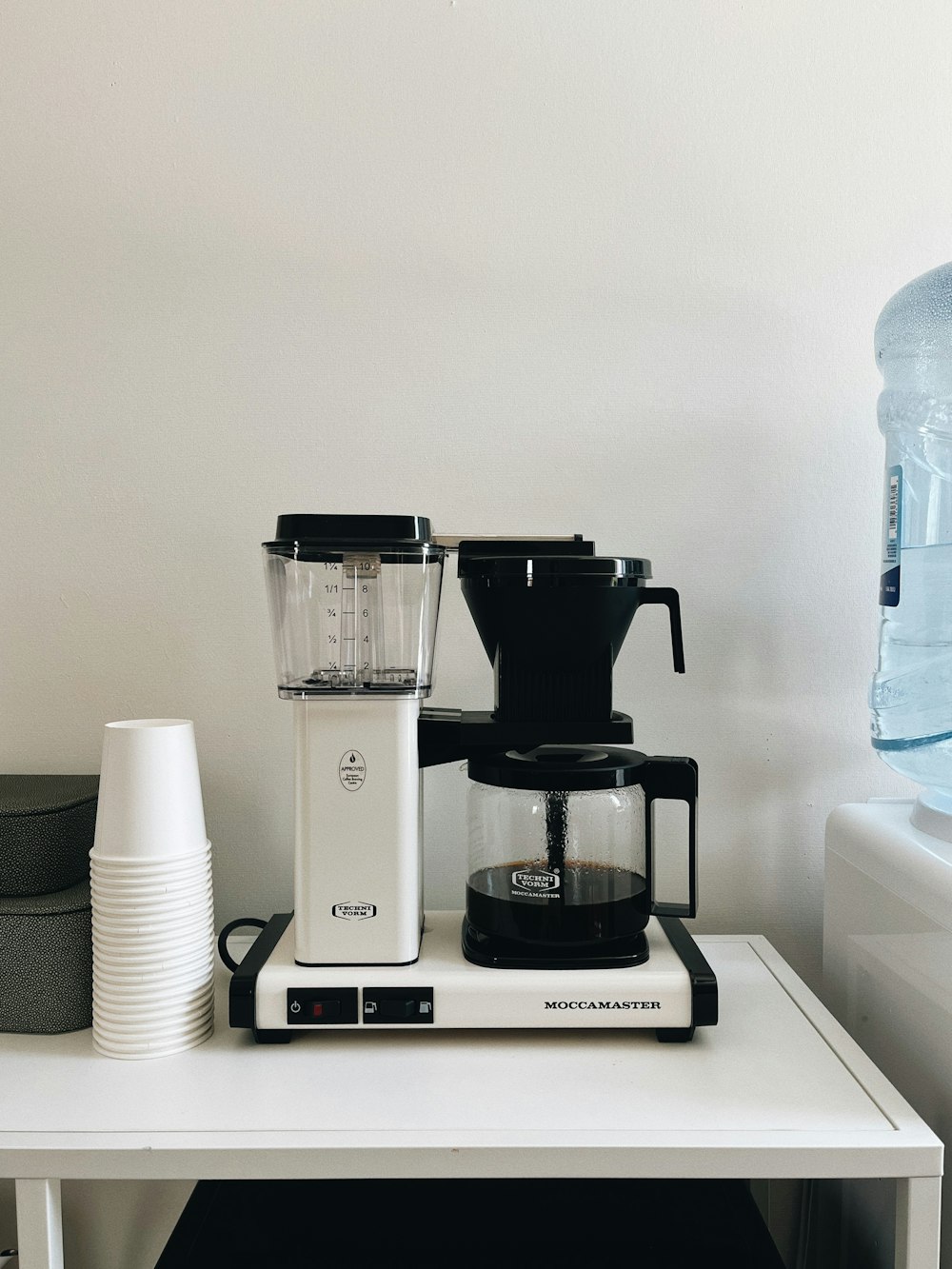 a coffee maker sitting on top of a white table