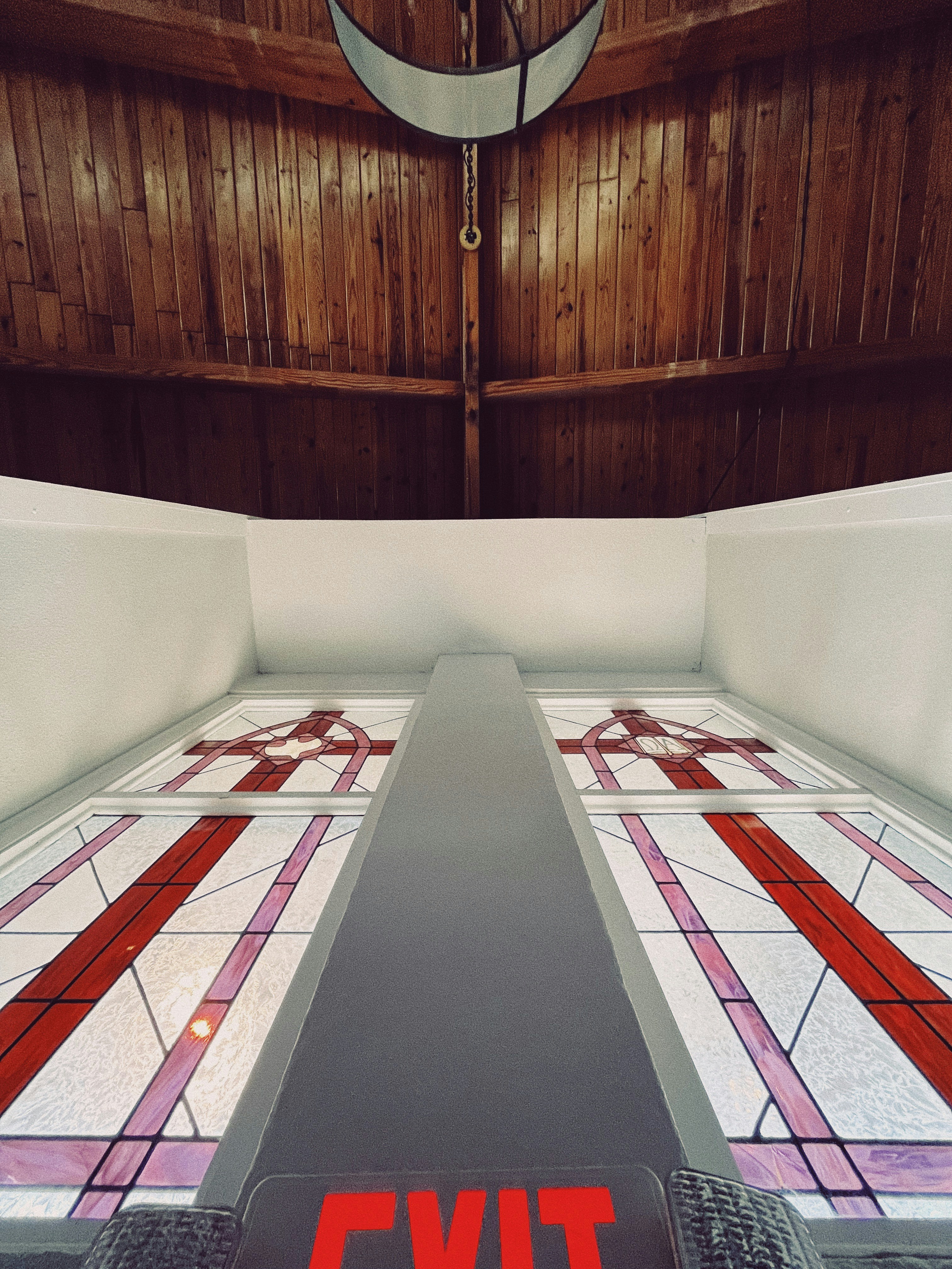 two beds in a room with wooden walls