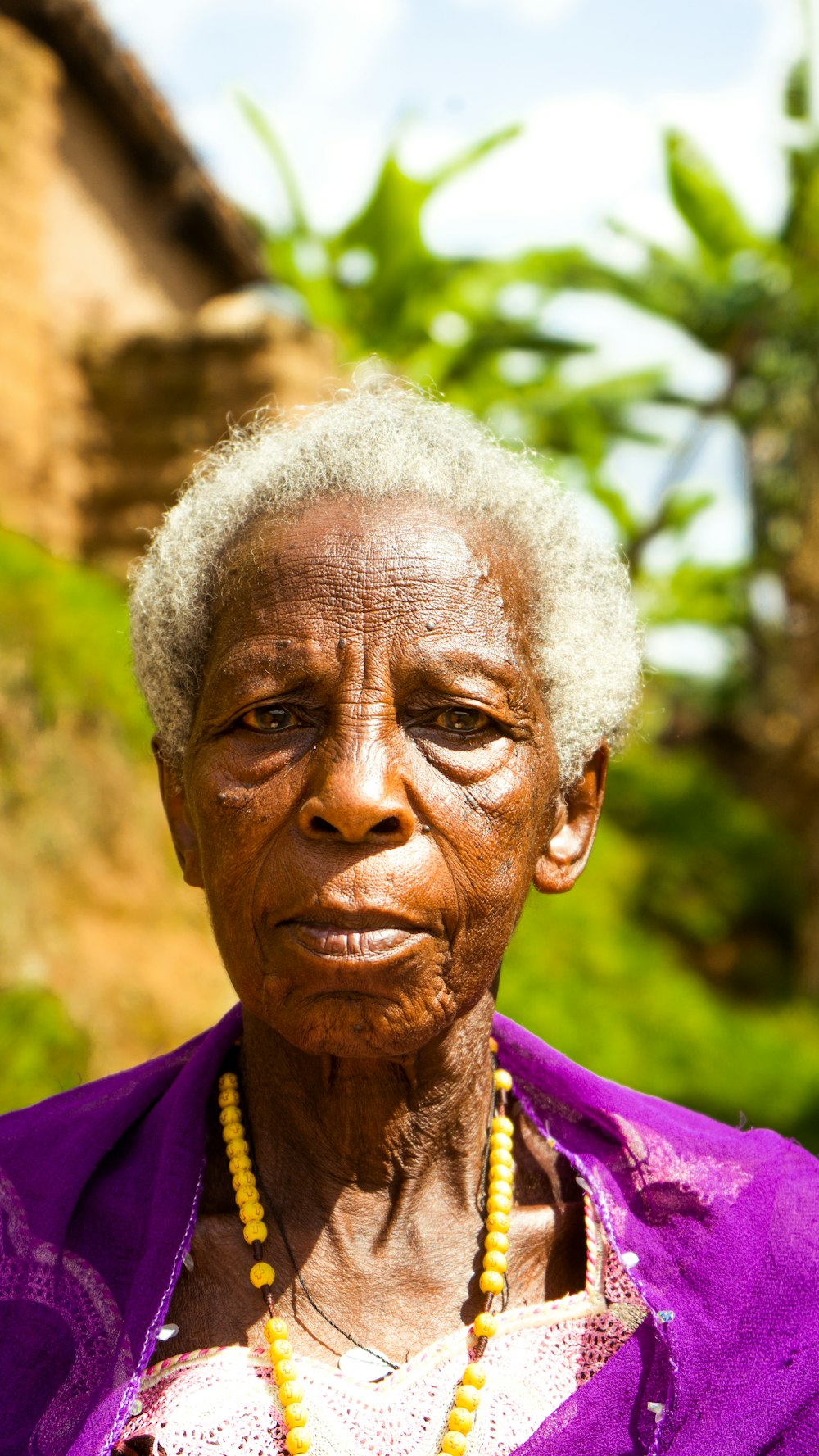 Une femme aux cheveux blancs portant une chemise violette