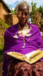 a woman in a purple dress is reading a book