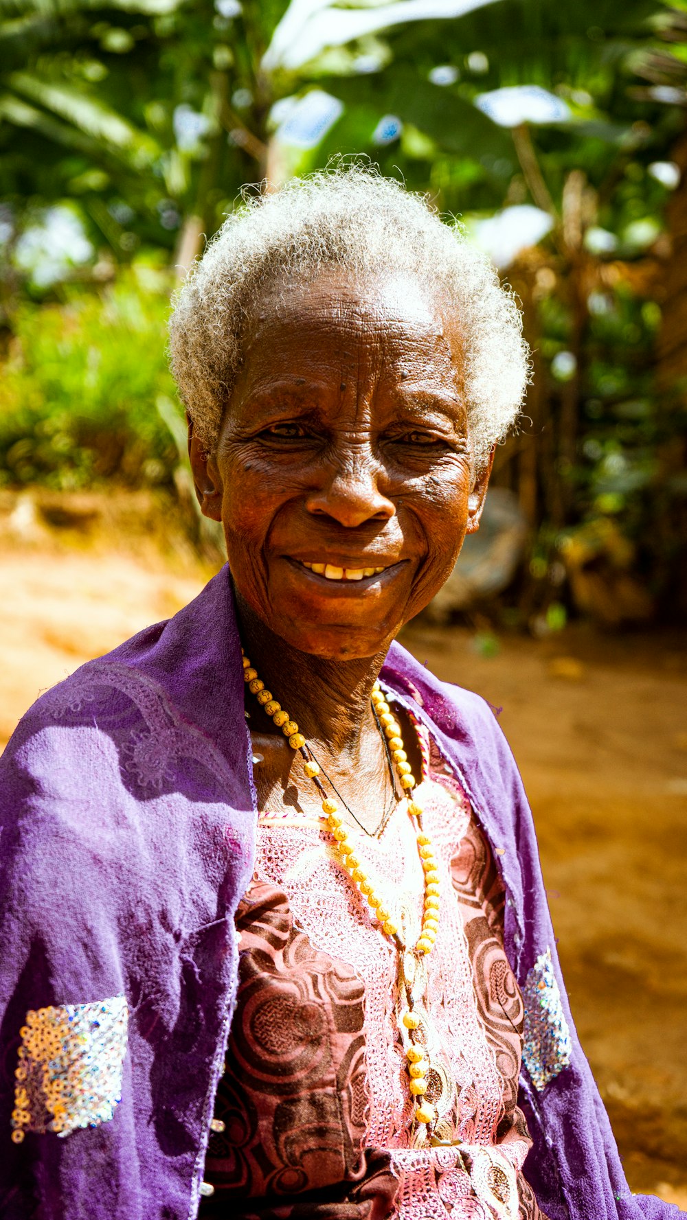 a woman in a purple jacket smiles at the camera