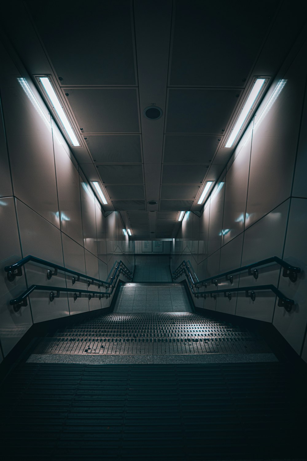 an empty hallway with a set of escalators