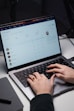 a person typing on a laptop on a desk