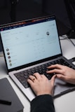 a person typing on a laptop on a desk