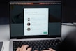 A laptop screen displaying a subscription confirmation message. The message includes a title saying 'Thanks for subscribing!' and introduces profiles of three individuals with their photographs and brief descriptions. The user's hands are visible typing on the laptop keyboard.