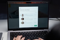 A laptop screen displaying a subscription confirmation message. The message includes a title saying 'Thanks for subscribing!' and introduces profiles of three individuals with their photographs and brief descriptions. The user's hands are visible typing on the laptop keyboard.