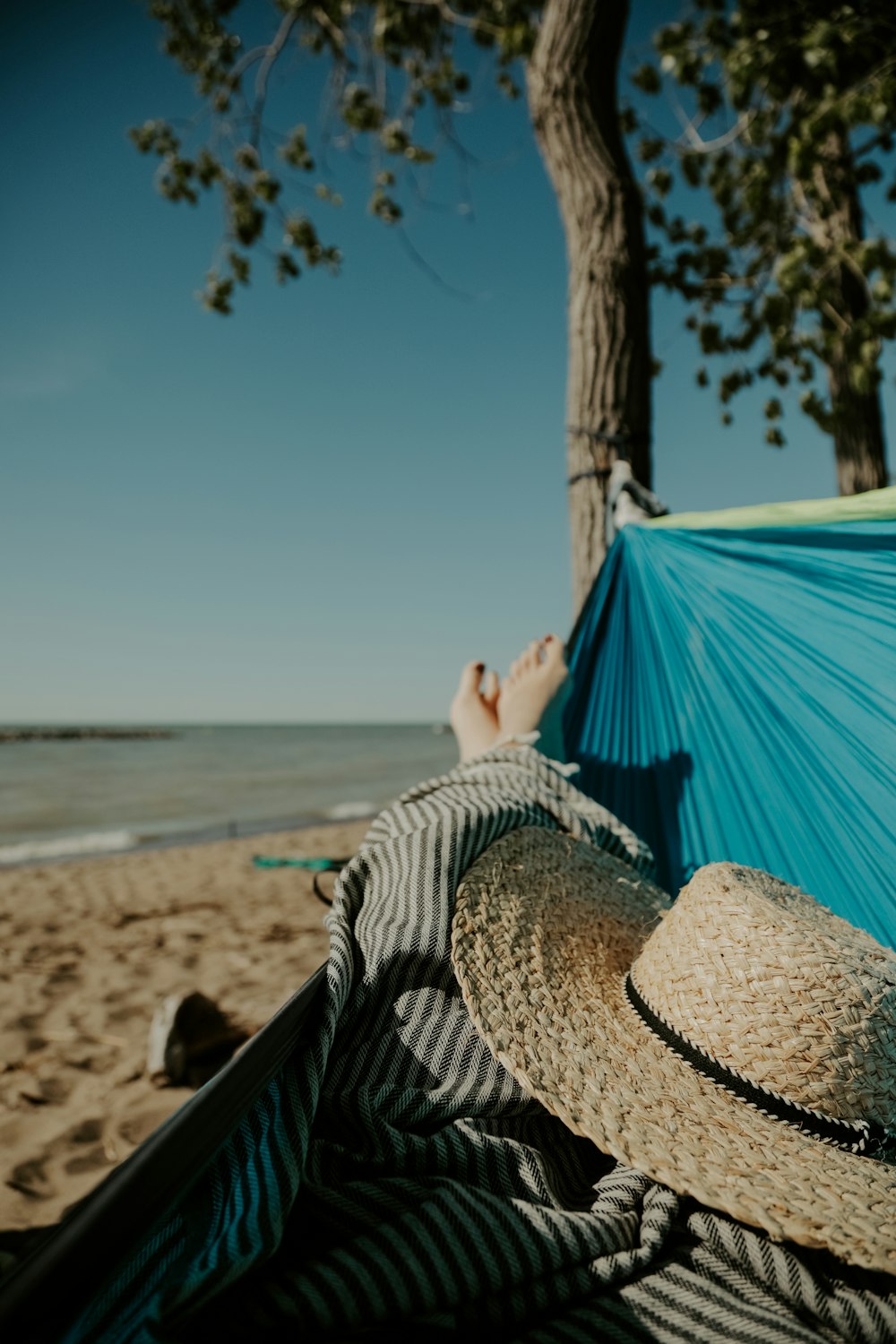 a person laying in a hammock on a beach