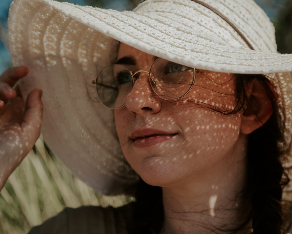 a woman wearing a white hat and glasses