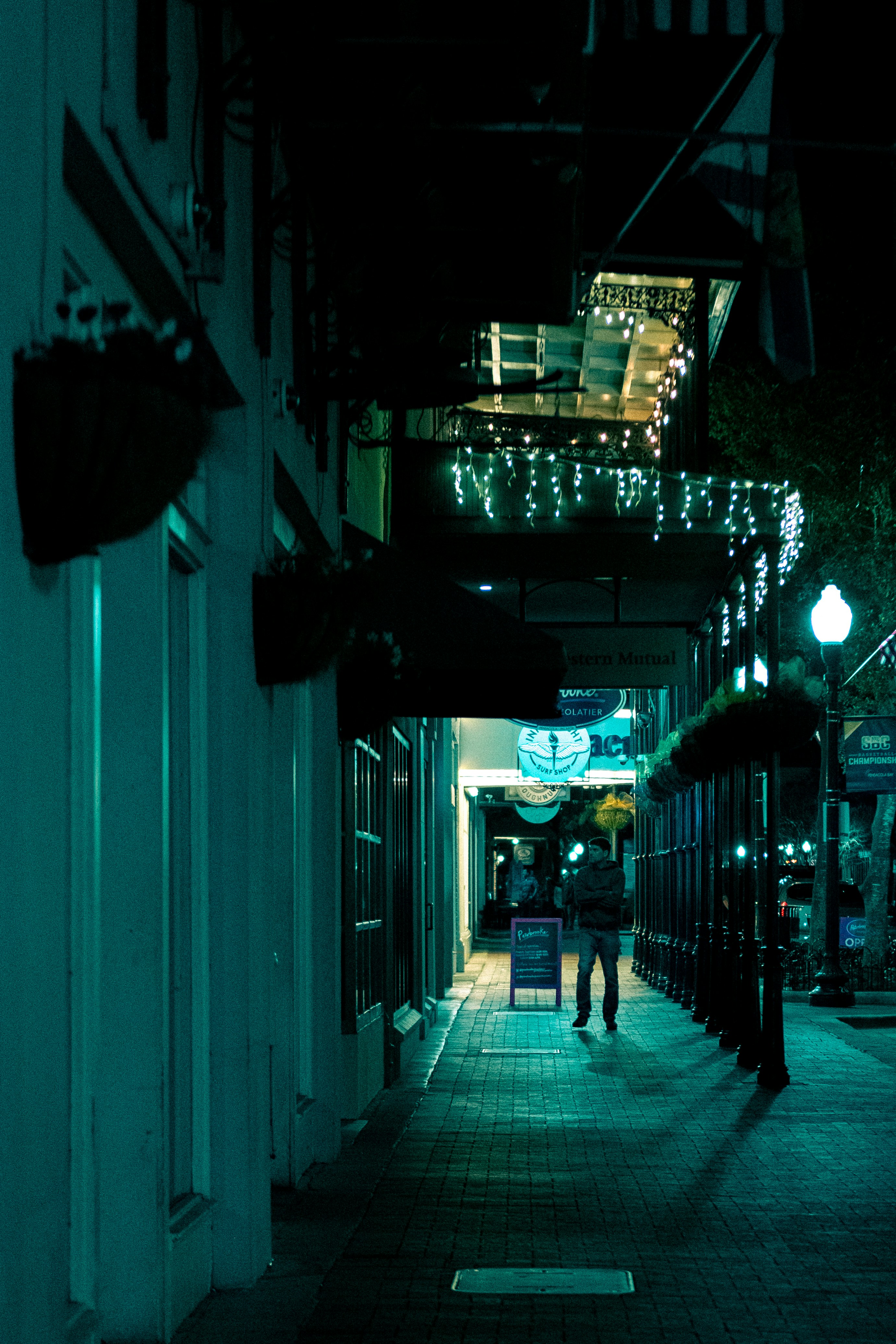 a couple of people walking down a street at night