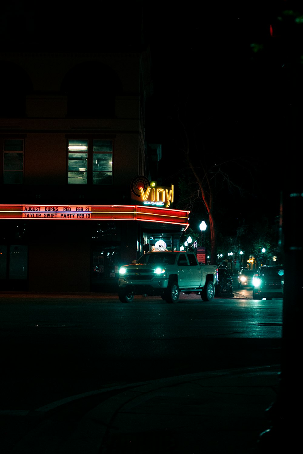 a car driving down a street at night