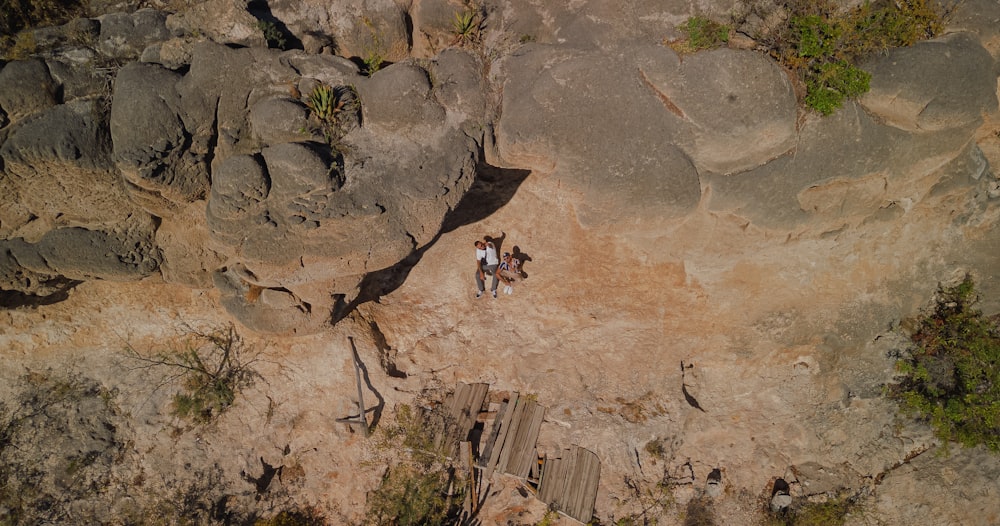 an aerial view of two people standing on rocks