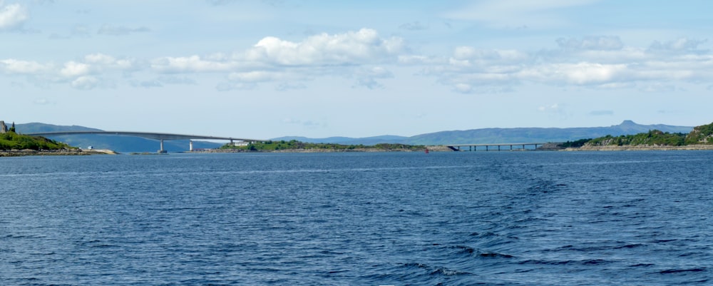 a large body of water with a bridge in the background