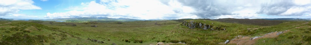 an aerial view of a grassy area with mountains in the background