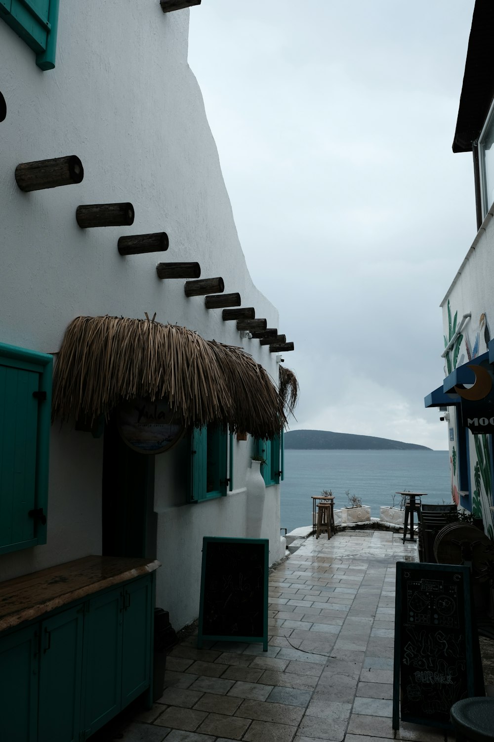 a building with a thatched roof next to a body of water