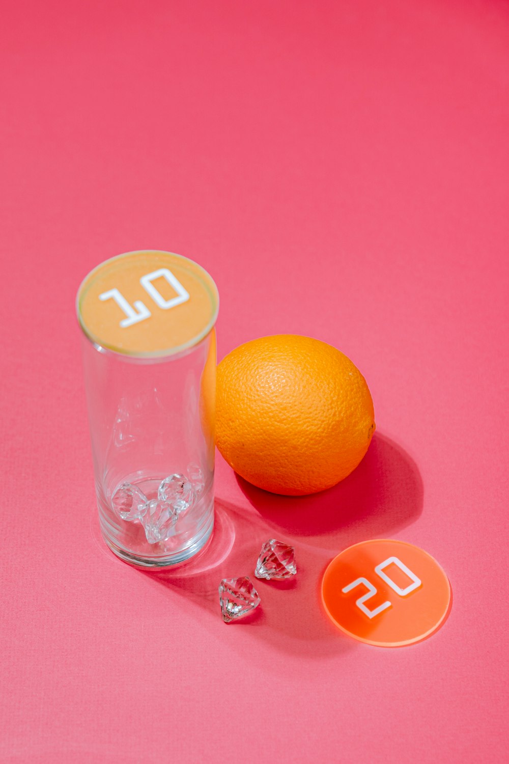 an orange sitting next to a glass of water