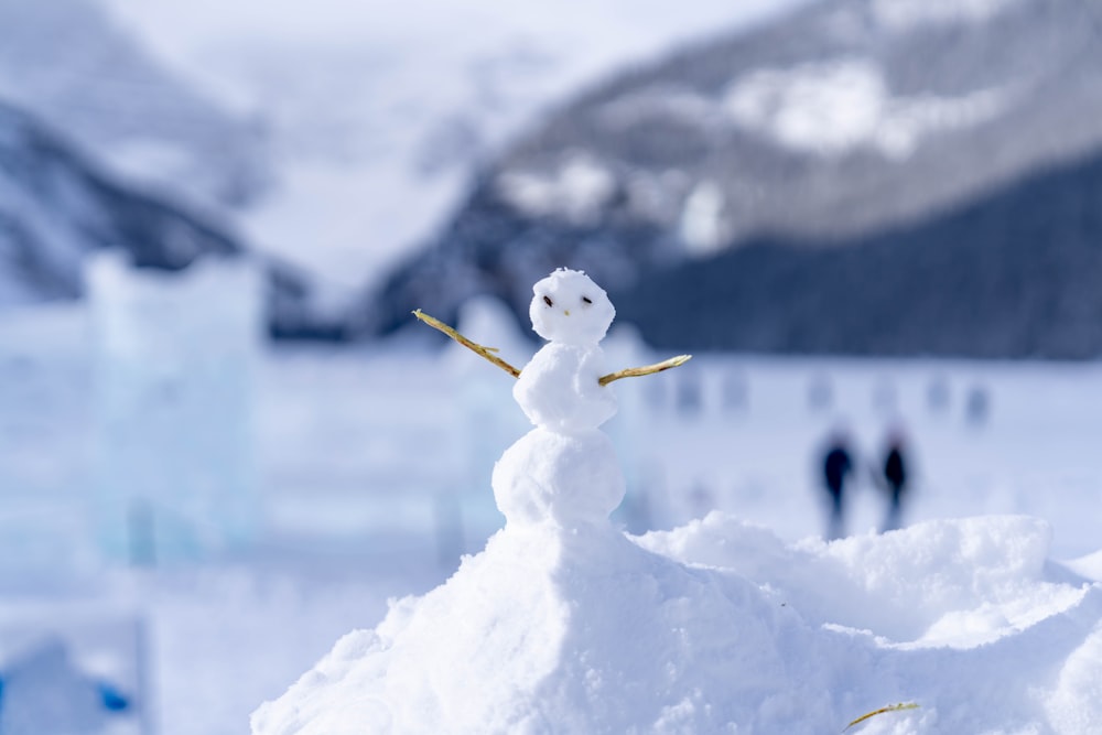 a snowman is standing on top of a pile of snow