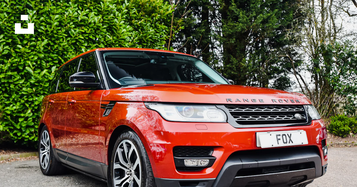 Un Range Rover rojo estacionado frente a un arbusto foto – Imagen de ...