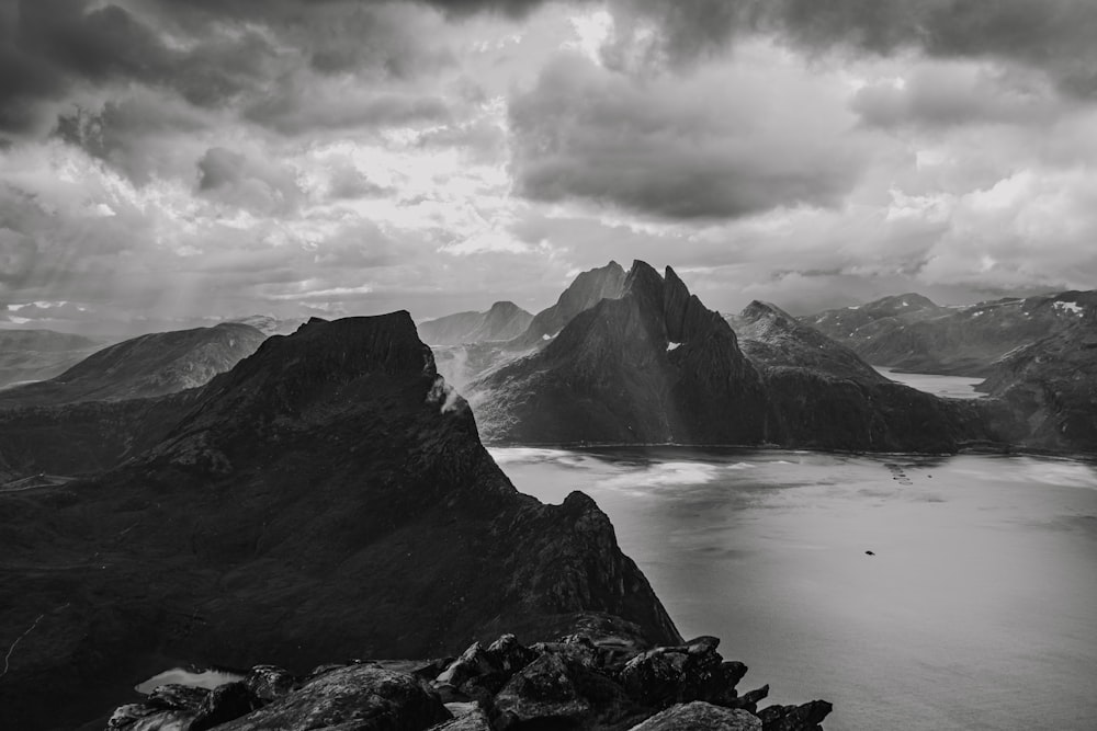 a black and white photo of mountains and a body of water