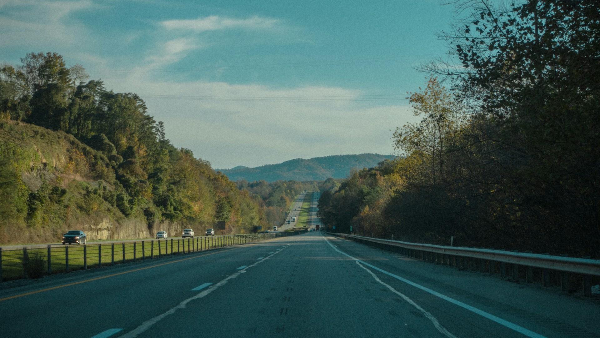 an empty road with a fence on the side of it