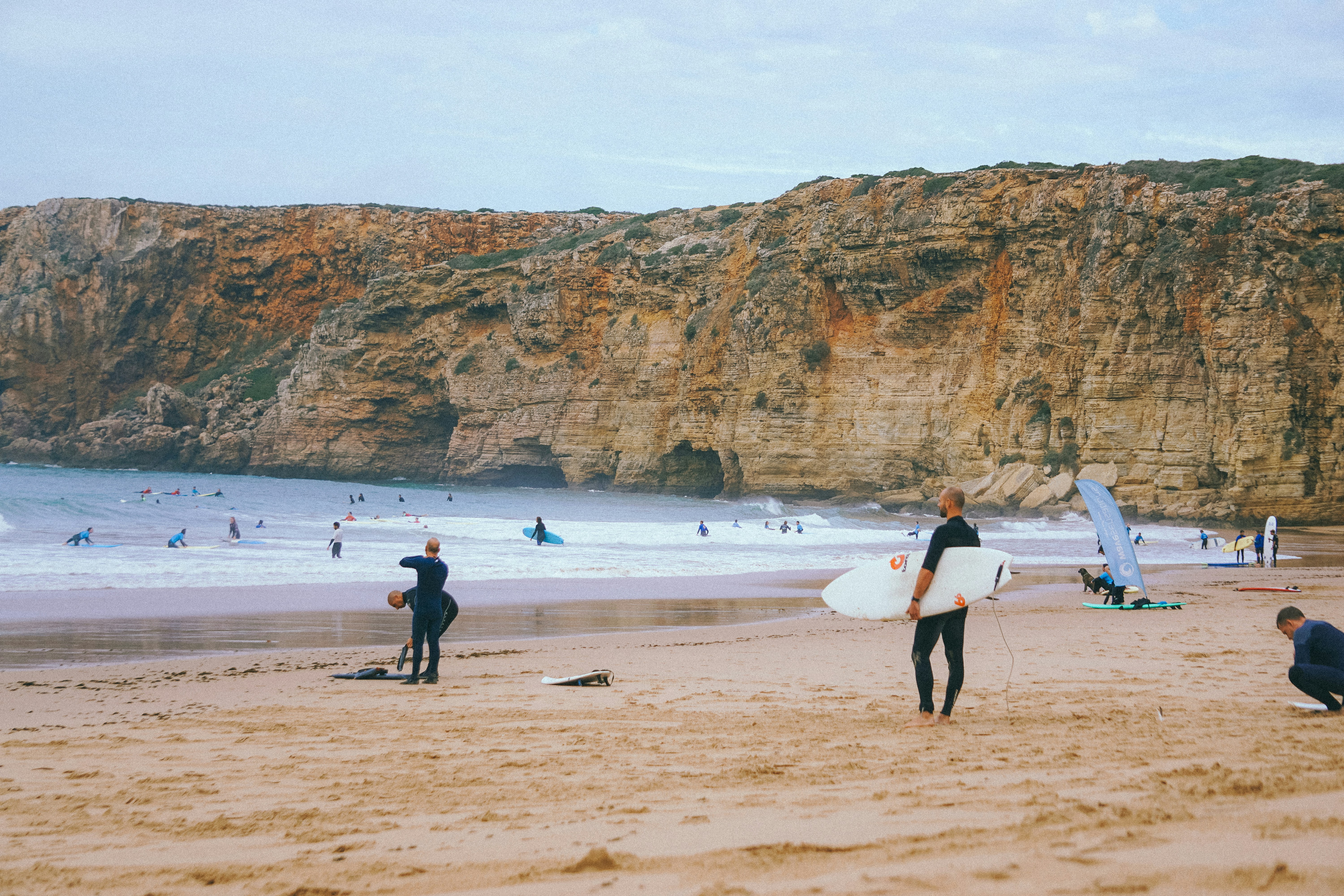 a group of people standing on top of a sandy beach