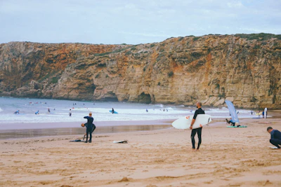a group of people standing on top of a sandy beach