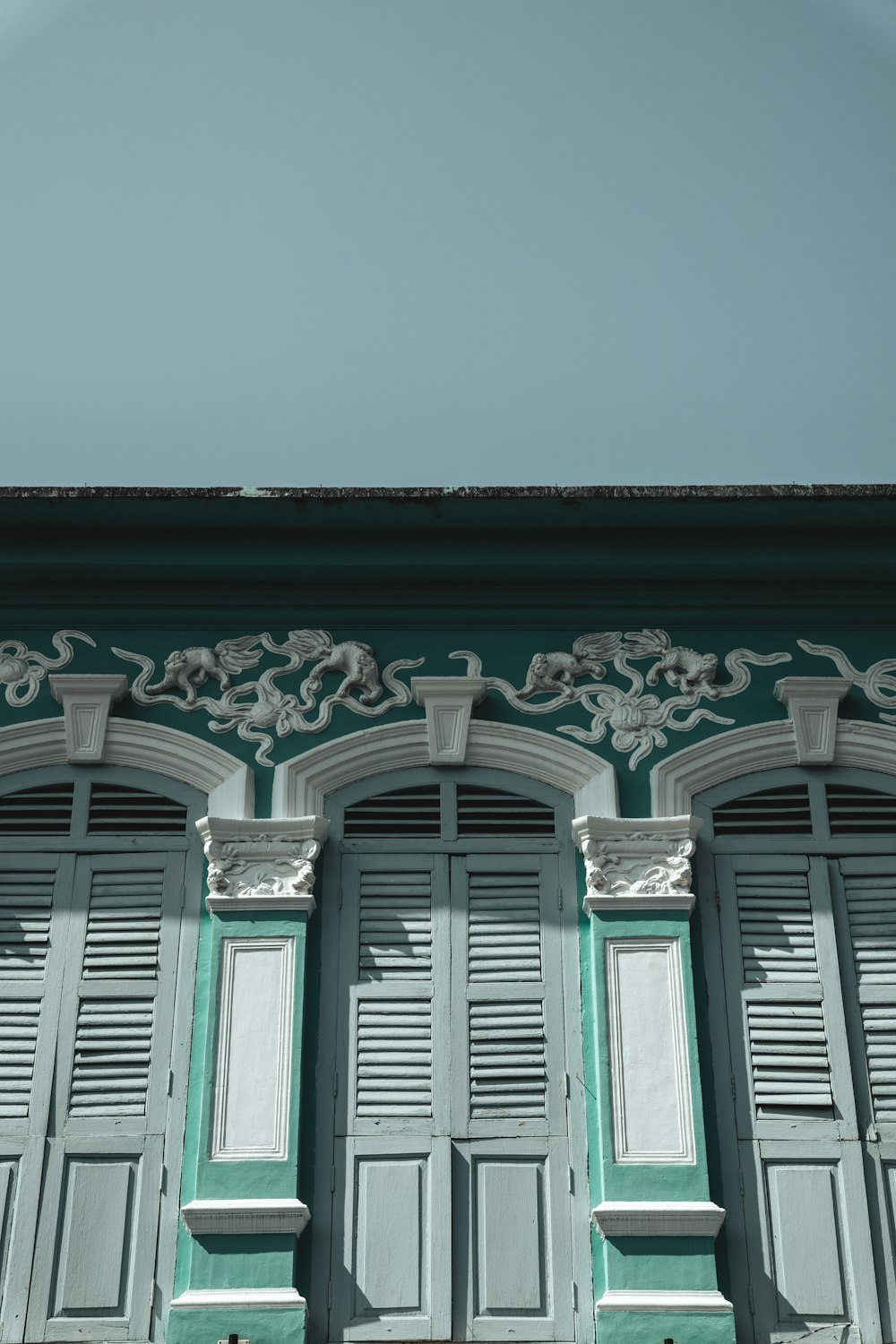 a green building with white trim and windows