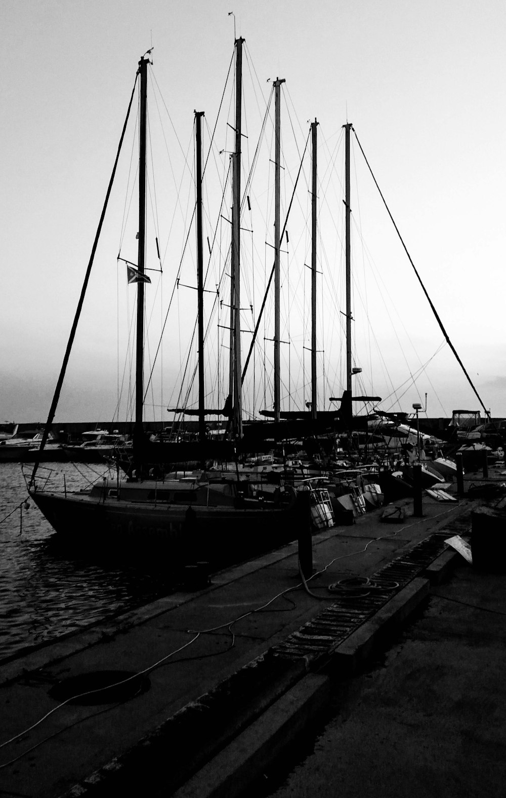 a black and white photo of a boat docked