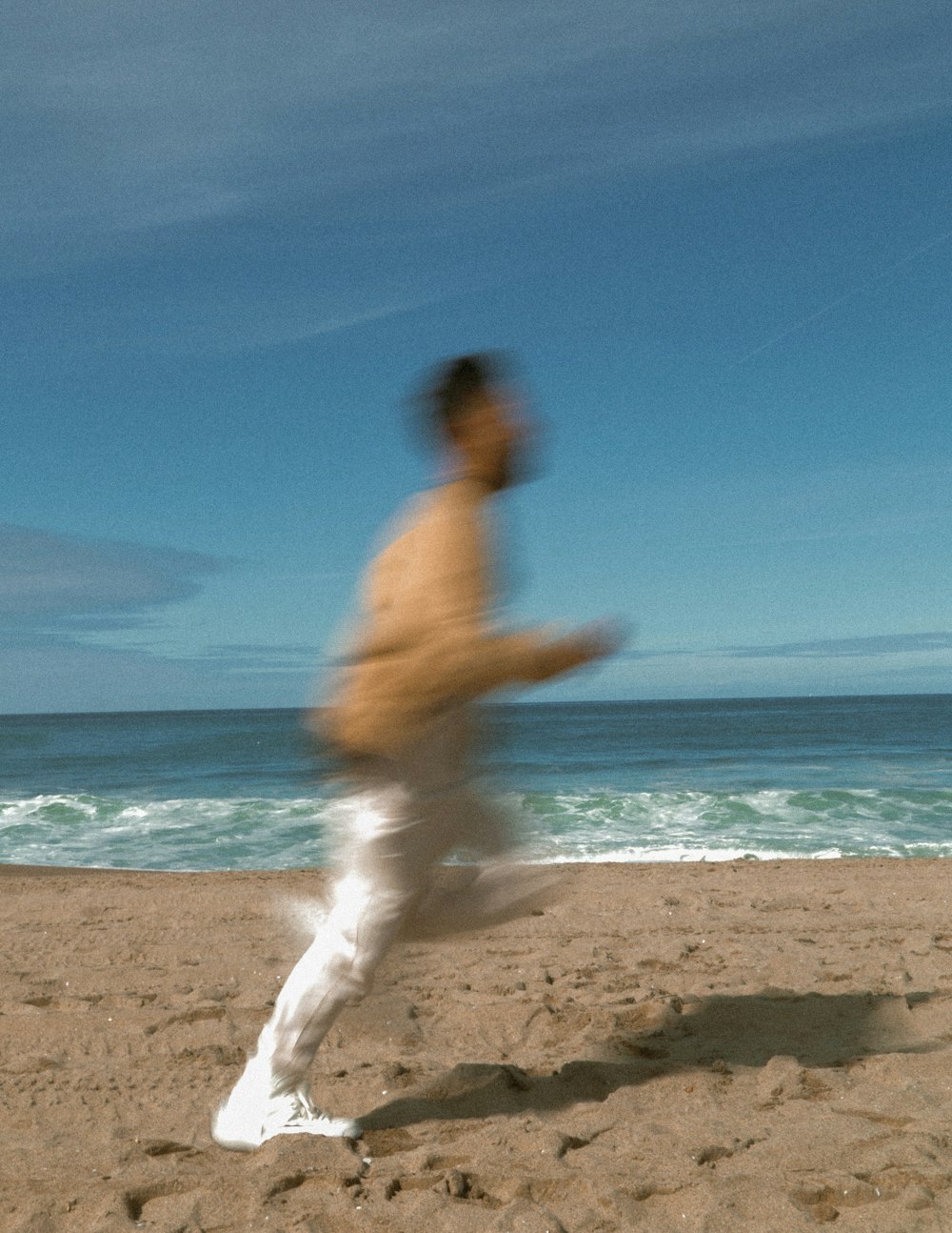 a blurry photo of a man running on the beach