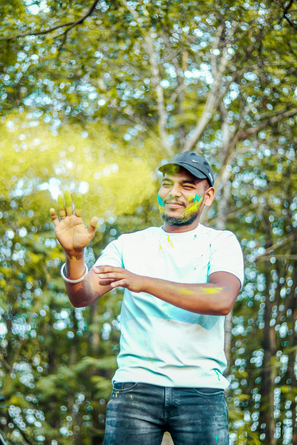 a man standing in front of a forest holding a green substance