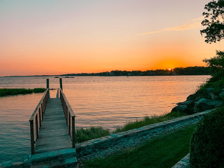 A serene view of a freshly installed wooden dock at Lac-Etchemin during sunset.