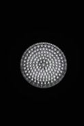 A circular light source composed of multiple small, bright LED bulbs, arranged densely in a grid pattern against a black background. The LEDs emit a cool white glow, creating a striking contrast.