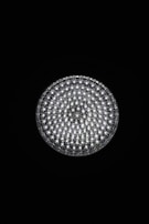 A circular light source composed of multiple small, bright LED bulbs, arranged densely in a grid pattern against a black background. The LEDs emit a cool white glow, creating a striking contrast.