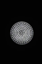 A circular light source composed of multiple small, bright LED bulbs, arranged densely in a grid pattern against a black background. The LEDs emit a cool white glow, creating a striking contrast.
