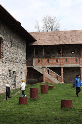 An archival image showing the original Enon Valley schoolhouse surrounded by children playing in the yard.