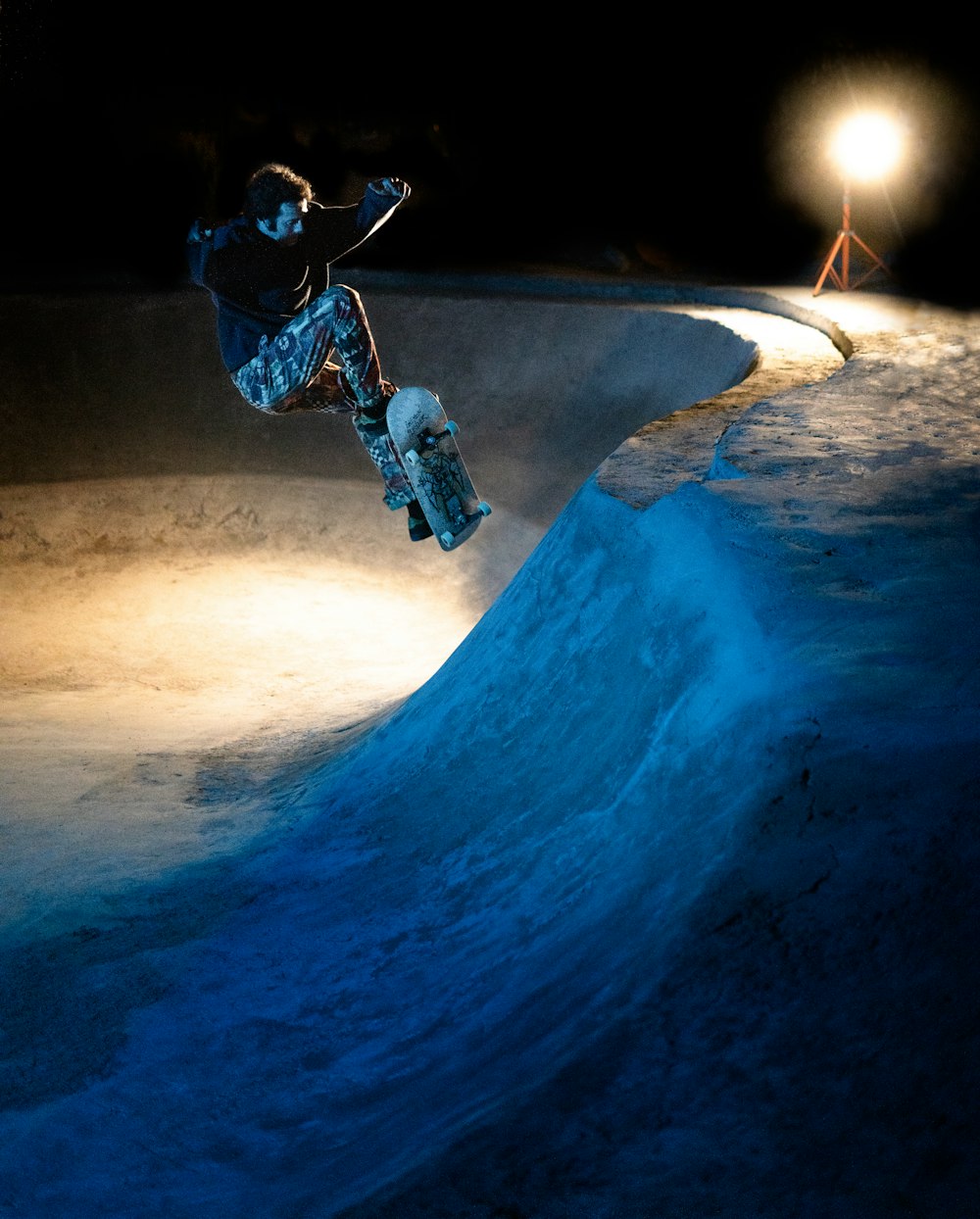 a man riding a snowboard down the side of a snow covered slope